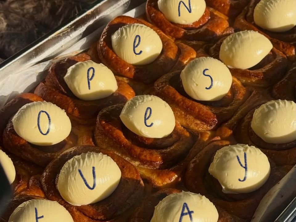 A tray of cinnamon buns with cream icing